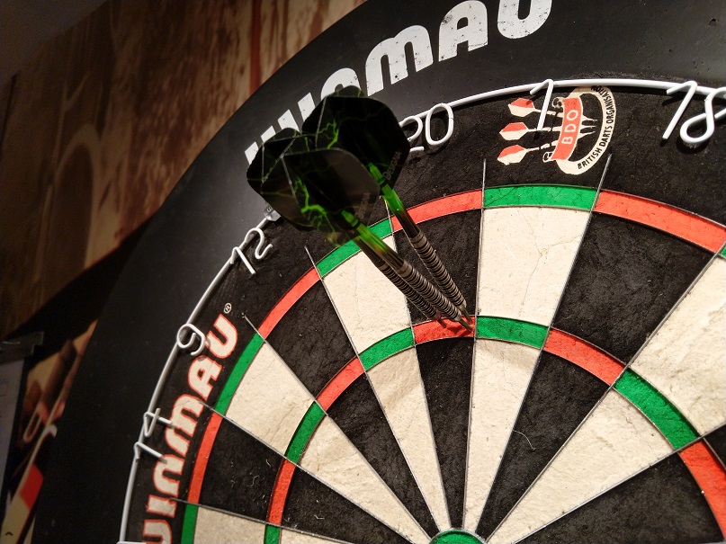 Dartboard with three darts.